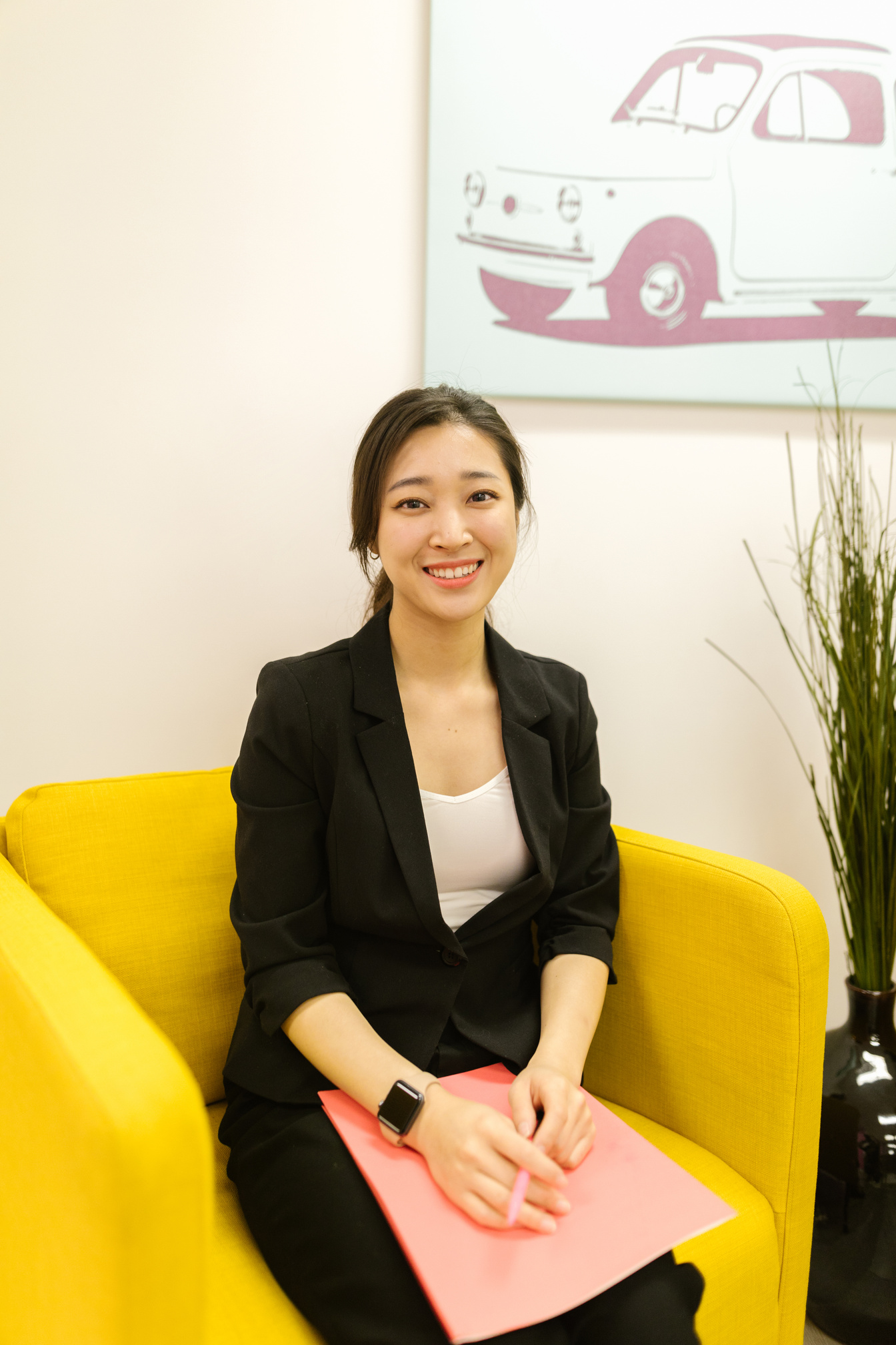 A Woman in Black Blazer Sitting on the Yellow Sofa